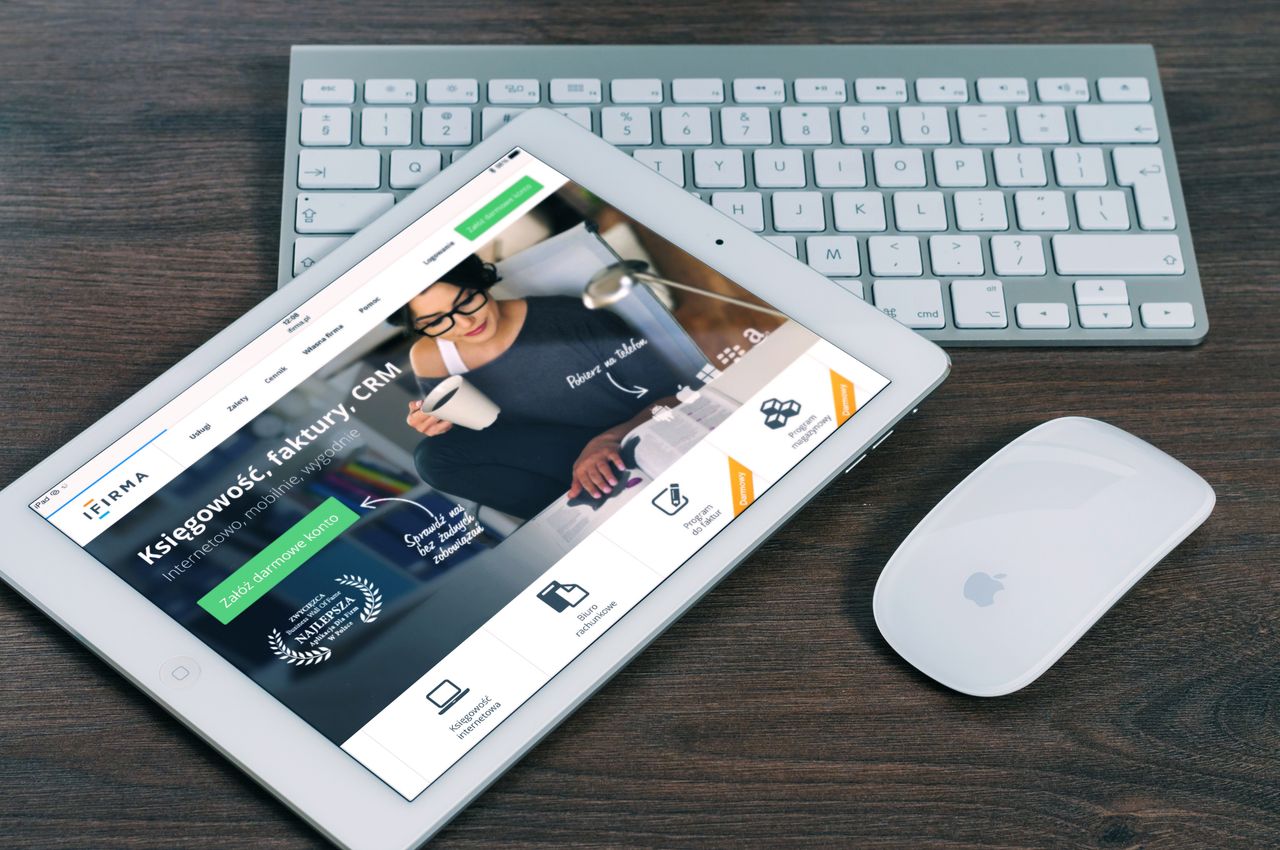 Une tablette affichant un site financier ouvert, à côté d’un clavier et d’une souris blancs. Parfait pour des images de stock sur le thème de la technologie.